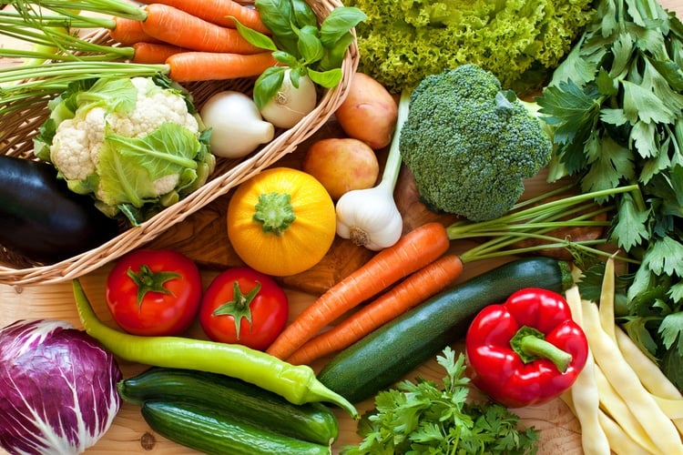 Assortment of fresh, colorful vegetables spread across a wooden table